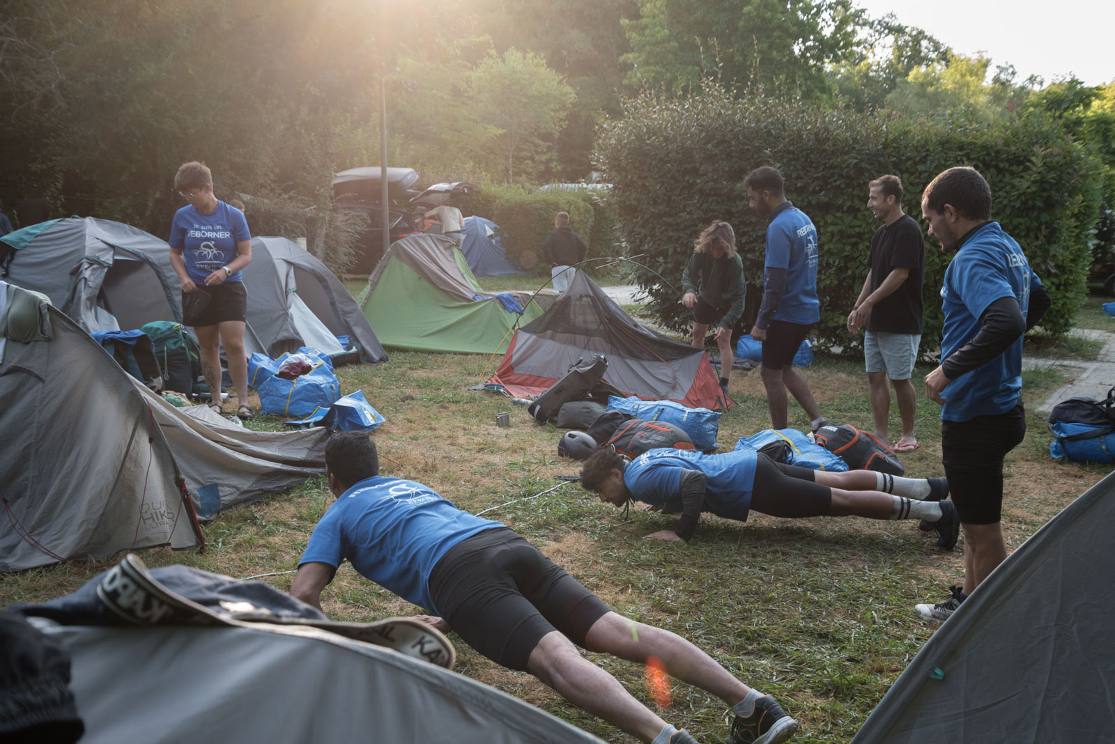 Refugees and volunteers warm up while others pack up their tents at the Blasimon campsite in the morning before setting off on the Reborn Trip bicycle tour of France in the Nouvelle-Aquitaine region on August 8, 2024.Des refugiees et des benevoles s echauffent pendant que d autres rangent leur tente au camping de Blasimon le matin avant de reprendre la traversee de la France a velo de Reborn Trip en Nouvelle-Aquitaine le 8 aout 2024.