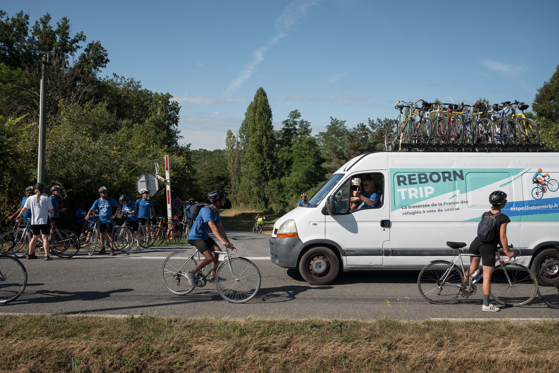 An employee drives the bike recovery truck out of the Blasimon campsite in the morning, among the participants ready to set off on the Reborn Trip bicycle tour of France in the Nouvelle-Aquitaine region on August 8, 2024.Un salarie conduit le camion de depannage des velos le matin a la sortie du camping de Blasimon au milieu des participants prets a rouler pendant la traversee de la France a velo de Reborn Trip en Nouvelle-Aquitaine le 8 aout 2024.