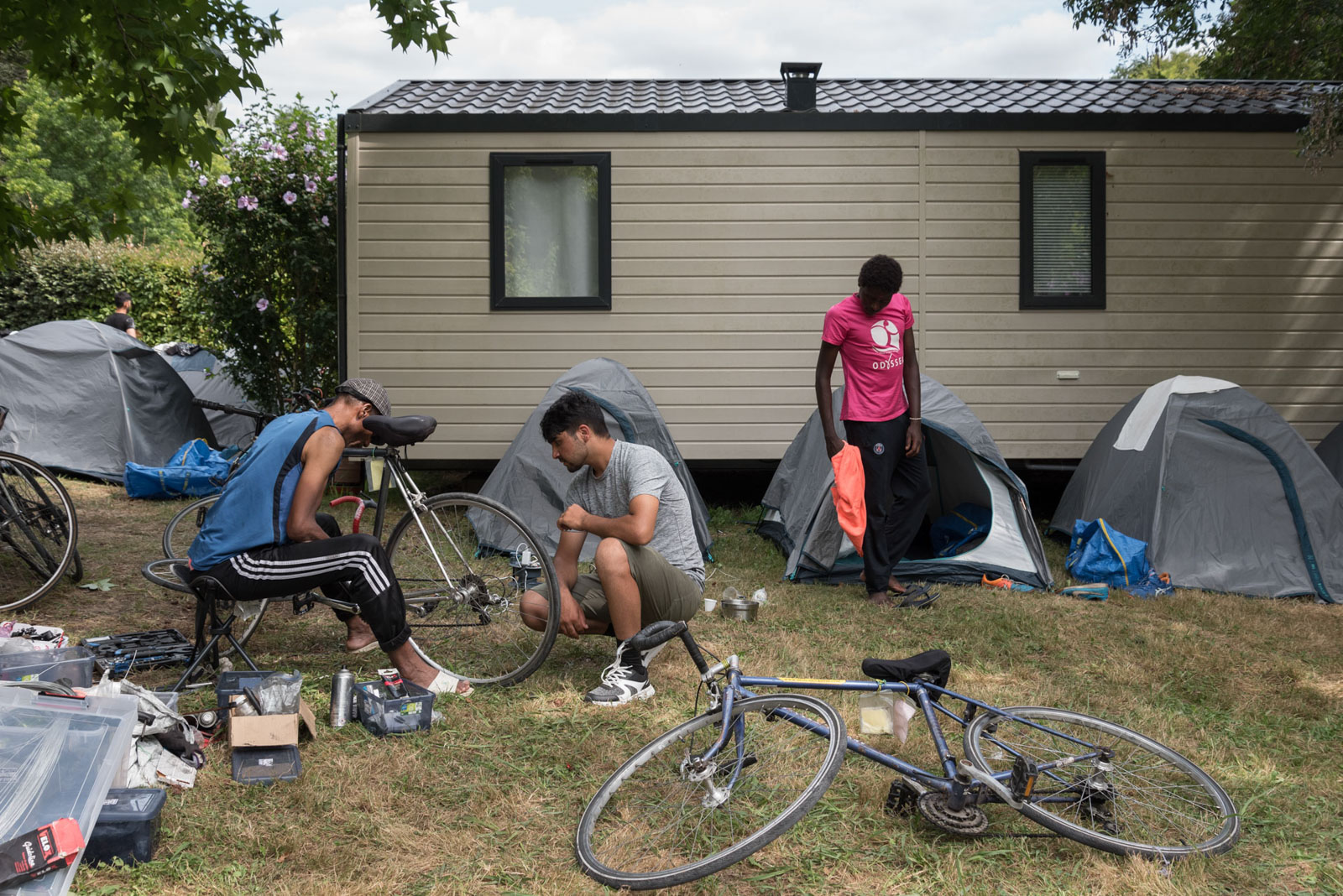 Refugees repair bicycles in front of the tents at the Blasimon campsite during the Reborn Trip cycling tour of France in Nouvelle-Aquitaine on August 7, 2024.Des refugies reparent les velos devant les tentes au camping de Blasimon pendant la traversee de la France a velo de Reborn Trip en Nouvelle-Aquitaine le 7 aout 2024.
