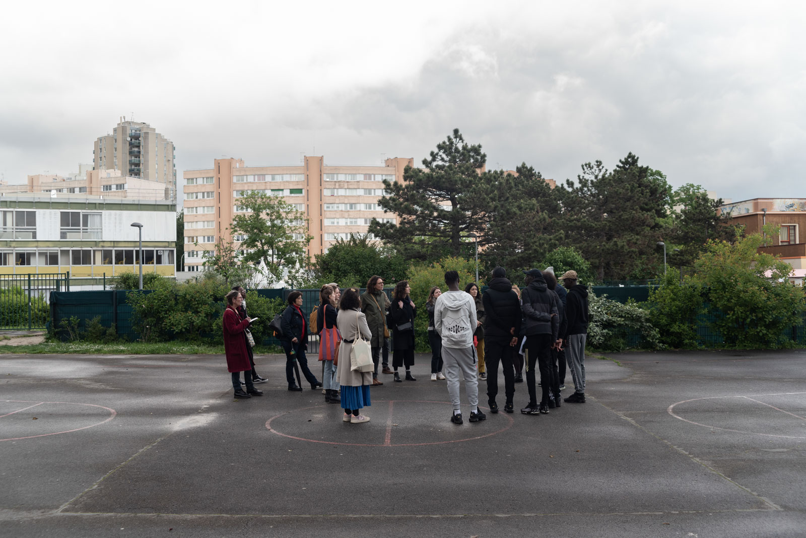 A group of visitors in round about the guides on the stadium of the college in the Palais district in Creteil in 2023.Un groupe de visiteurs en ronde autour des guides sur le stade du college dans le quartier du Palais a Creteil en 2023.